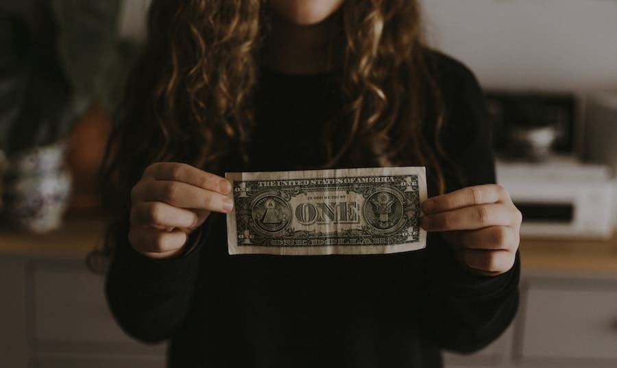 girl holding one dollar
